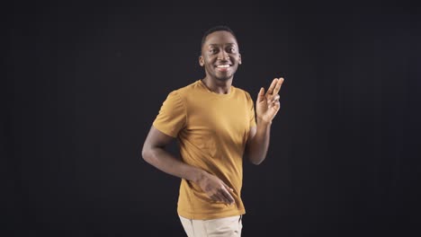 Handsome-and-charismatic-African-young-man-dancing-and-having-fun-on-black-background.